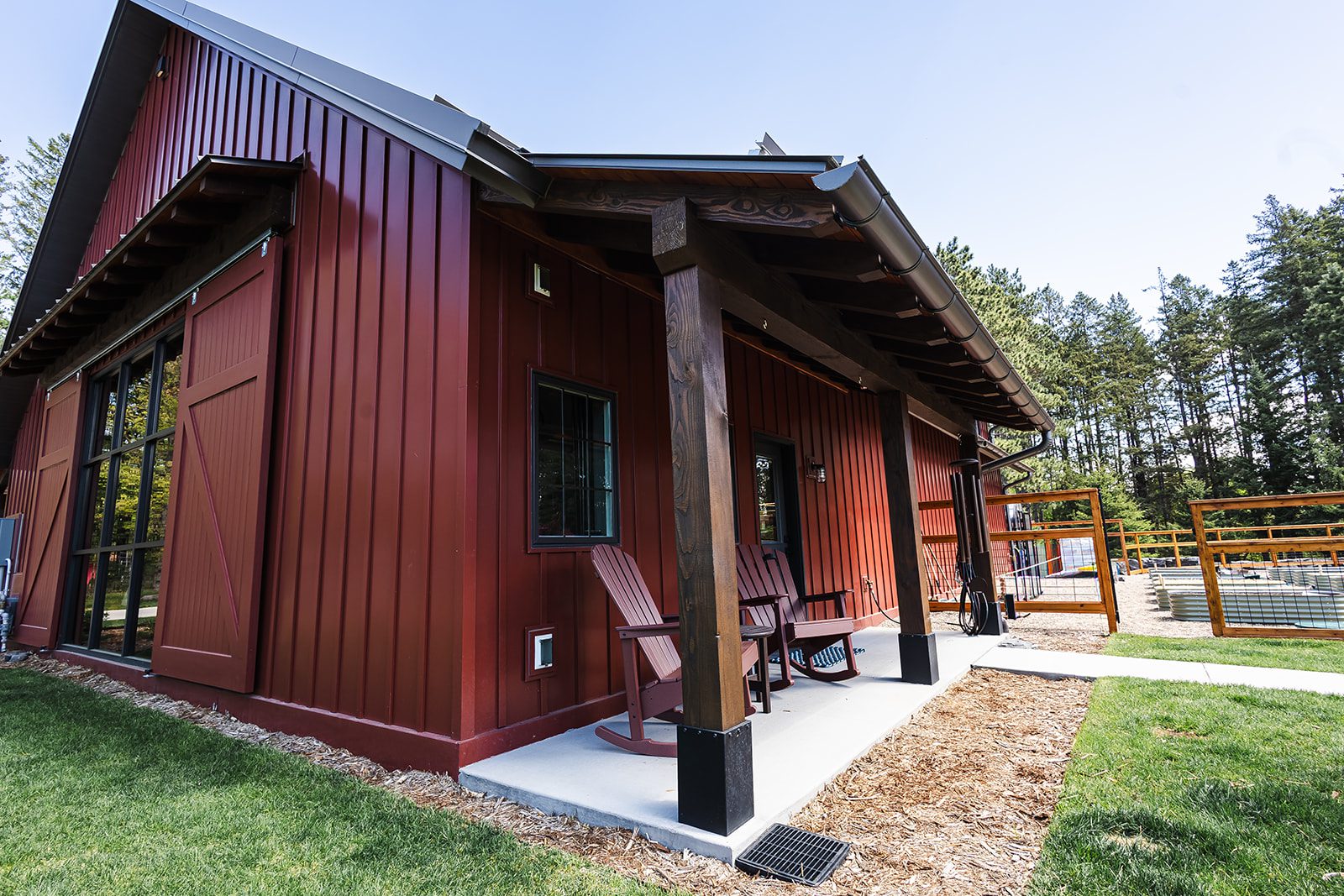 Red barn-style building with porch and chairs