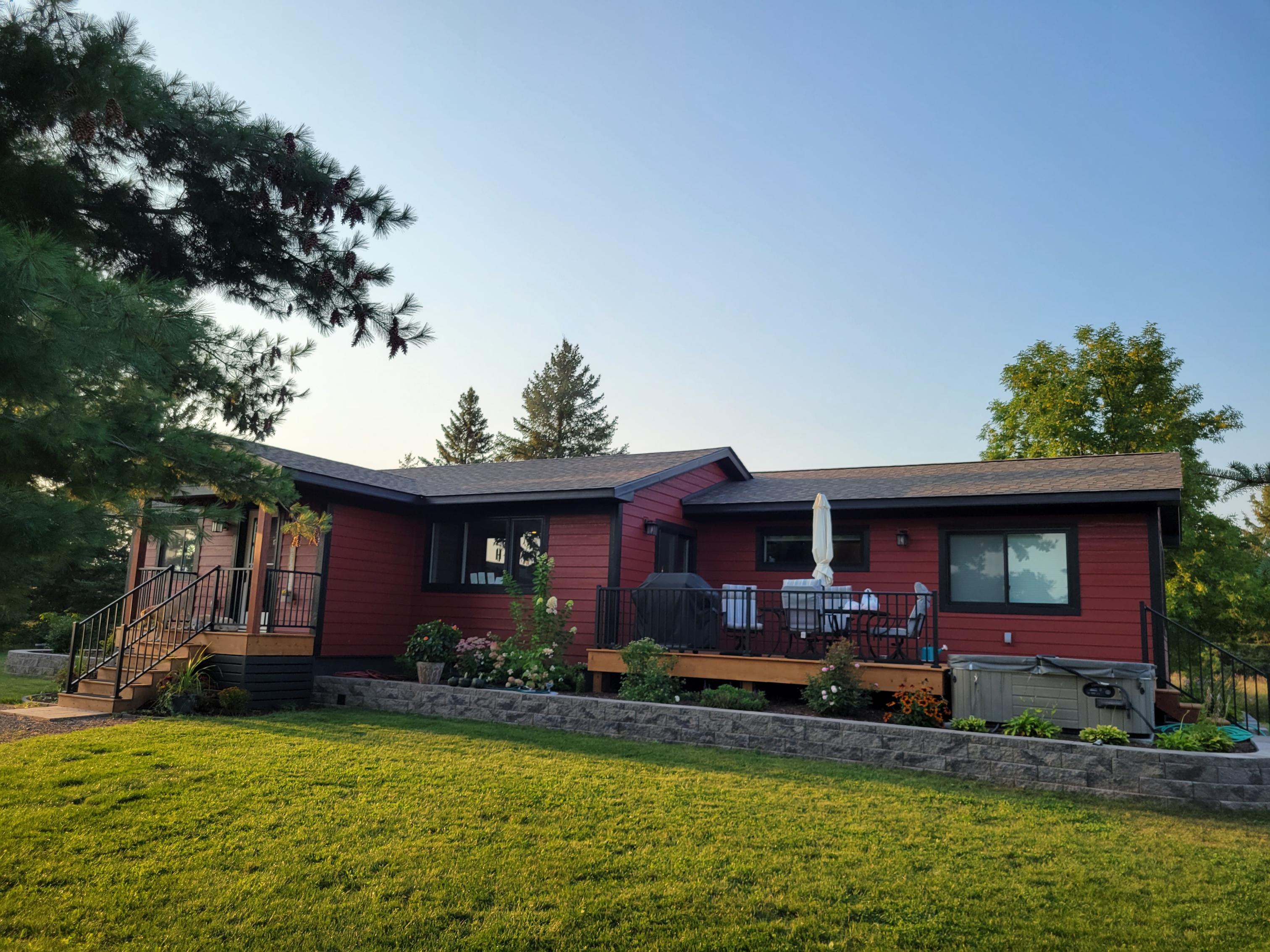 Red single-story house with deck and lawn
