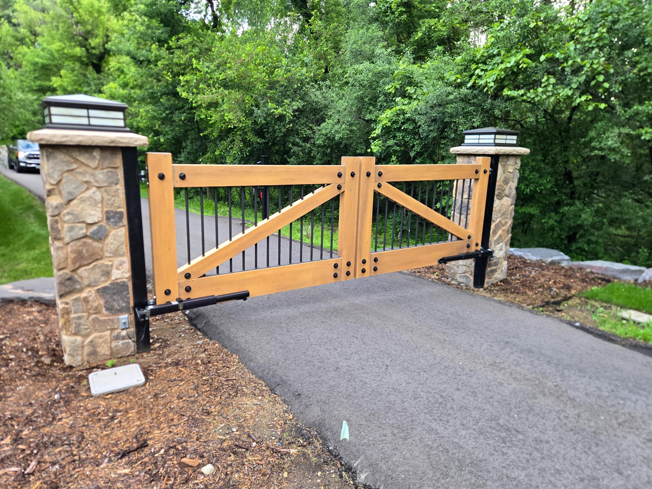 Wooden driveway gate between stone pillars