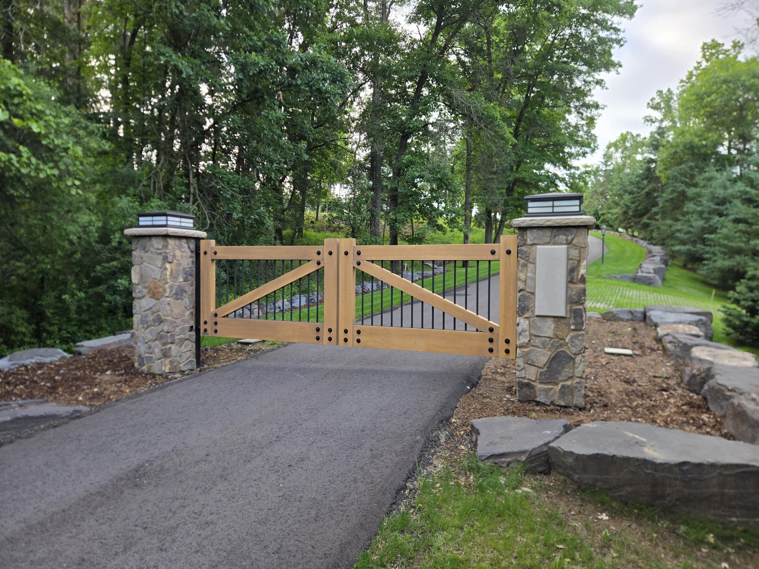 Wooden driveway gate between stone pillars