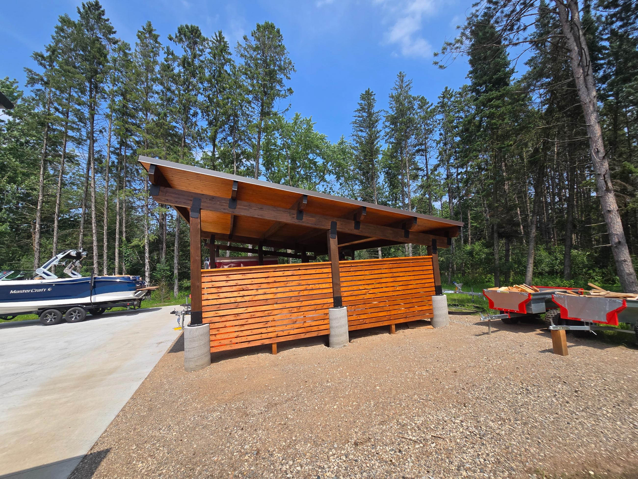Wooden slatted shelter near boats in forest