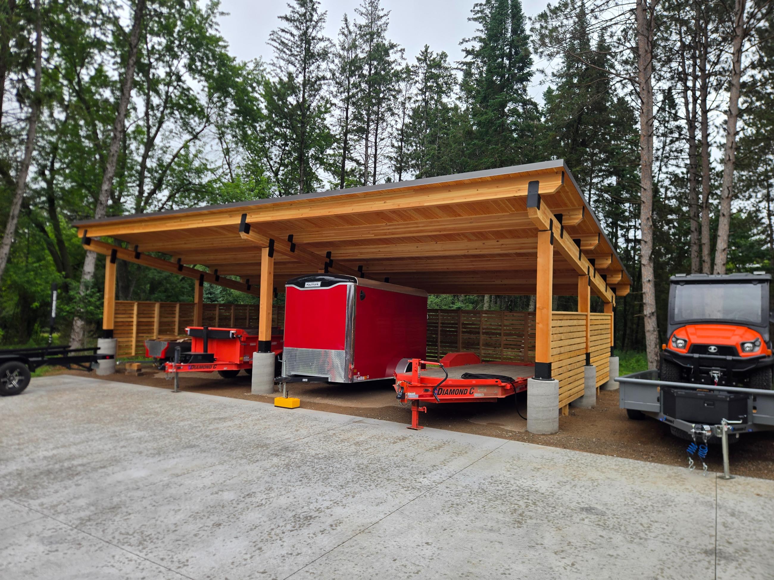 Covered wooden shelter with trailers and equipment