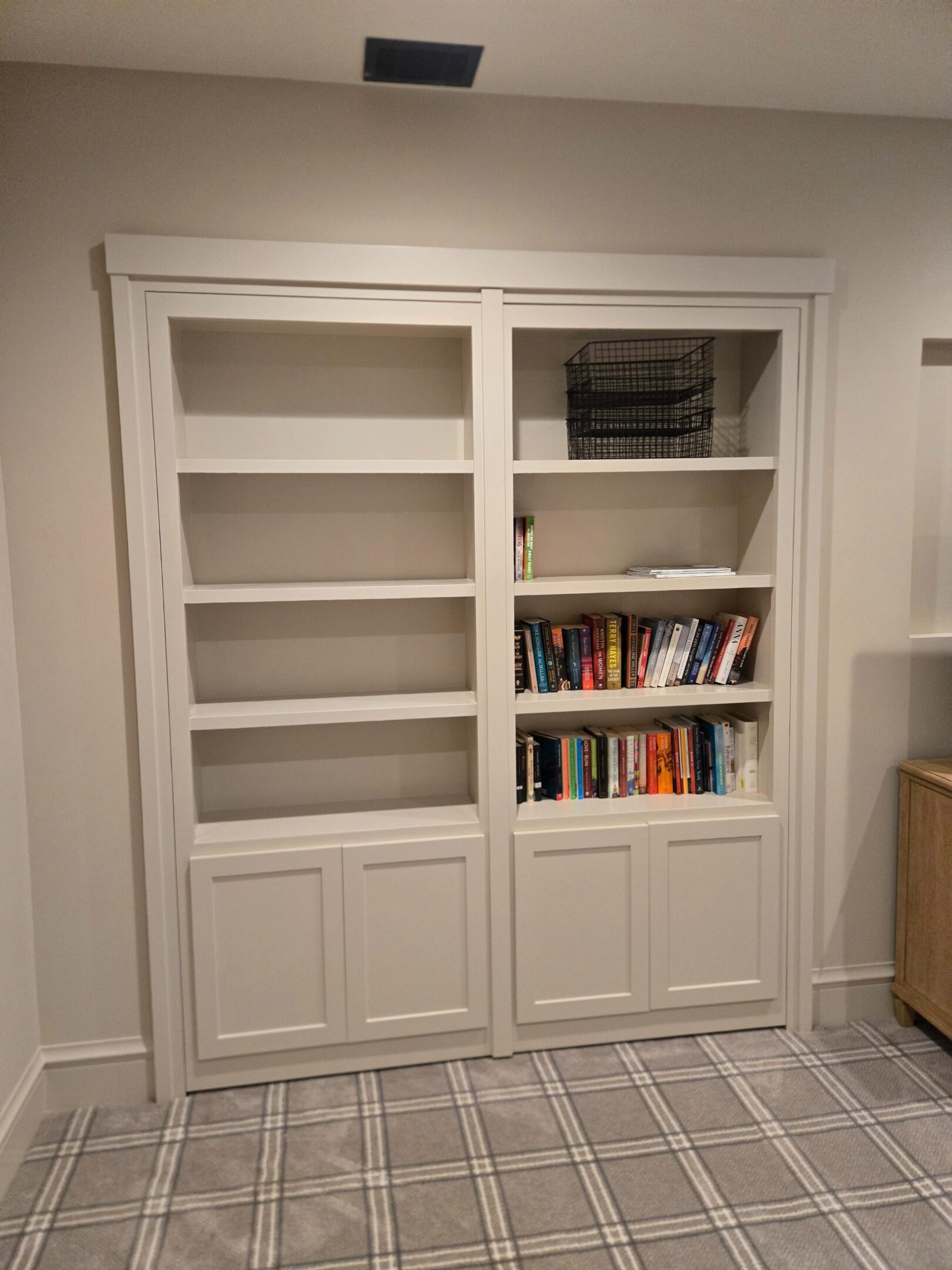 White built-in bookshelves with books and baskets