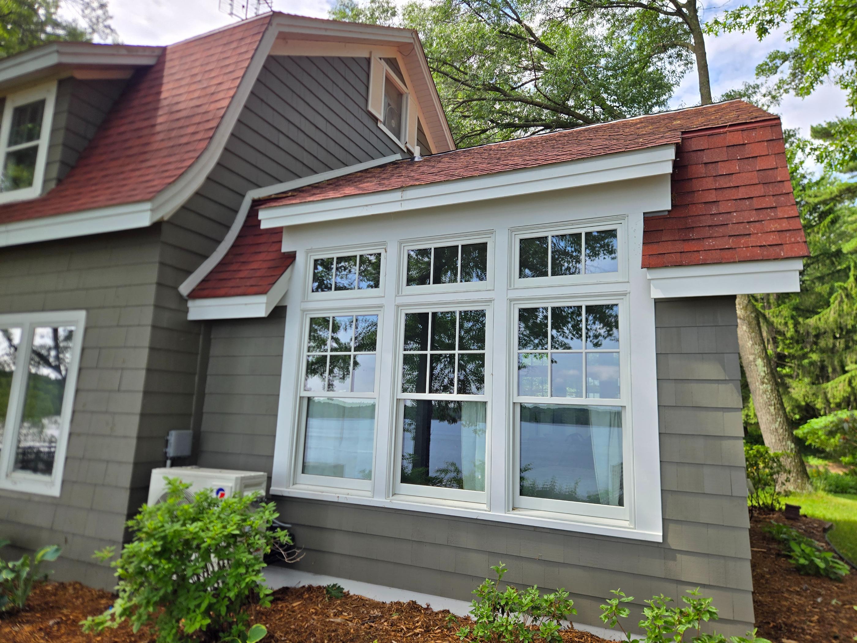 Gray lakeside house with large bay window