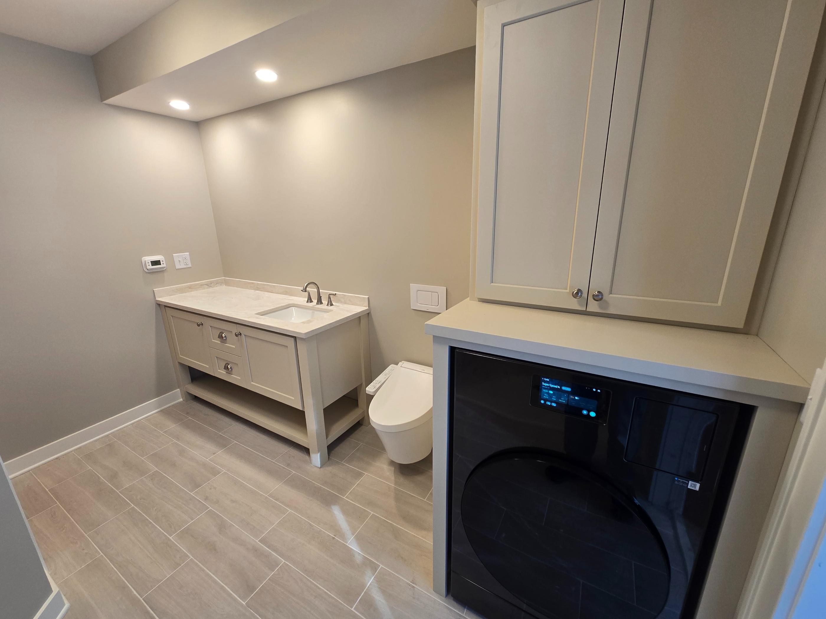 Modern laundry room with toilet and vanity