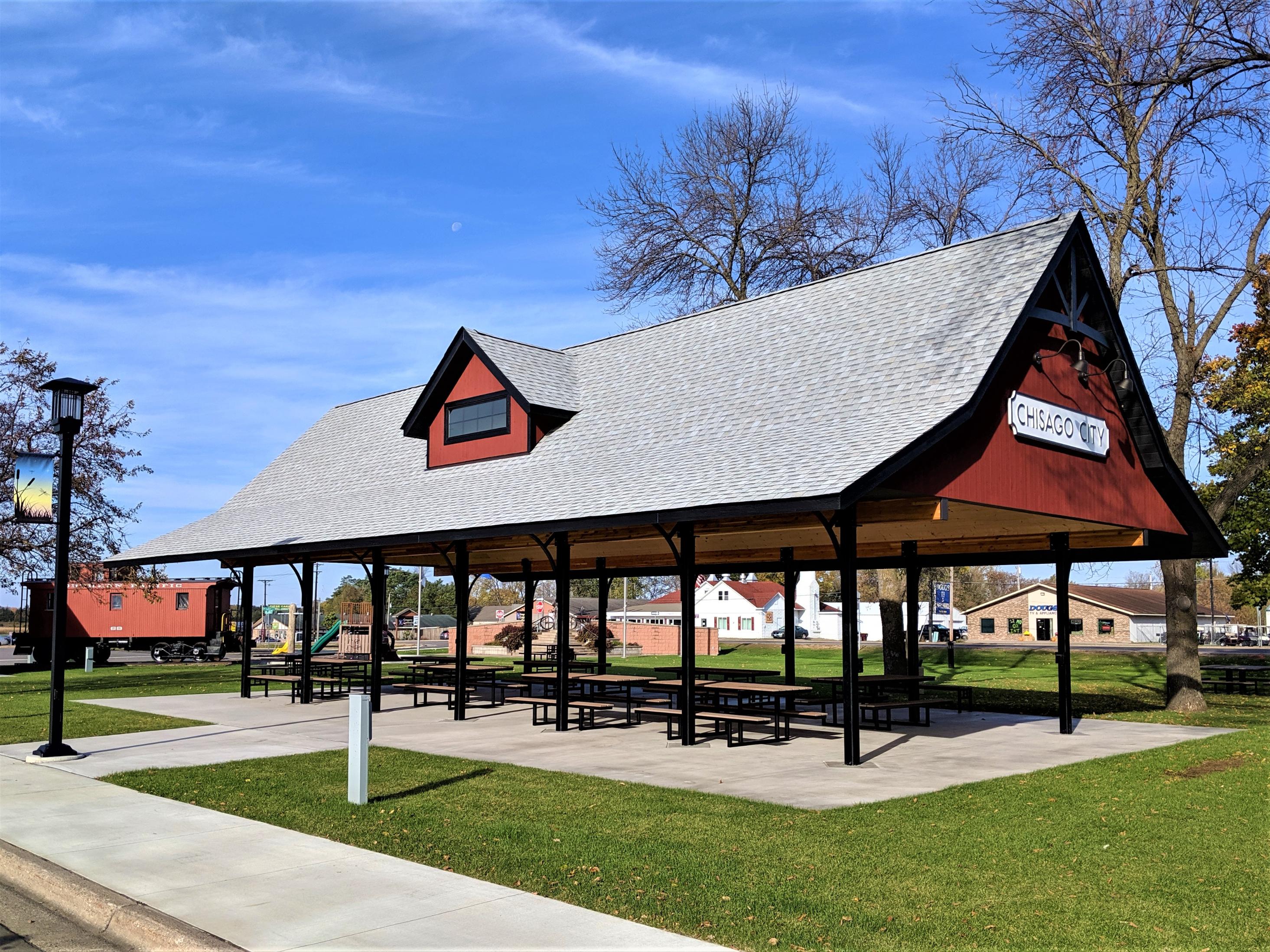 Red-trimmed park pavilion with picnic tables
