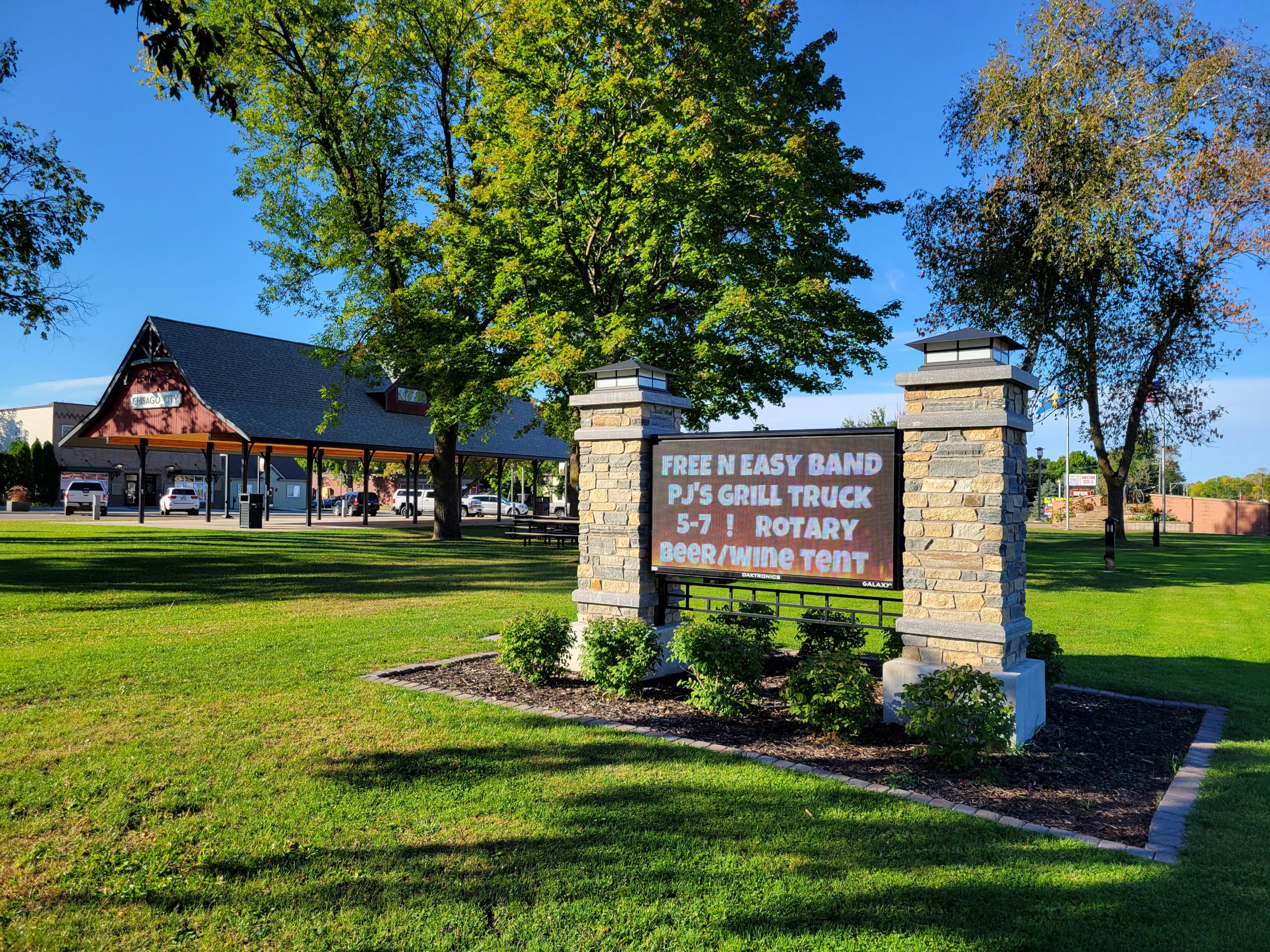 Grassy park with pavilion and event sign