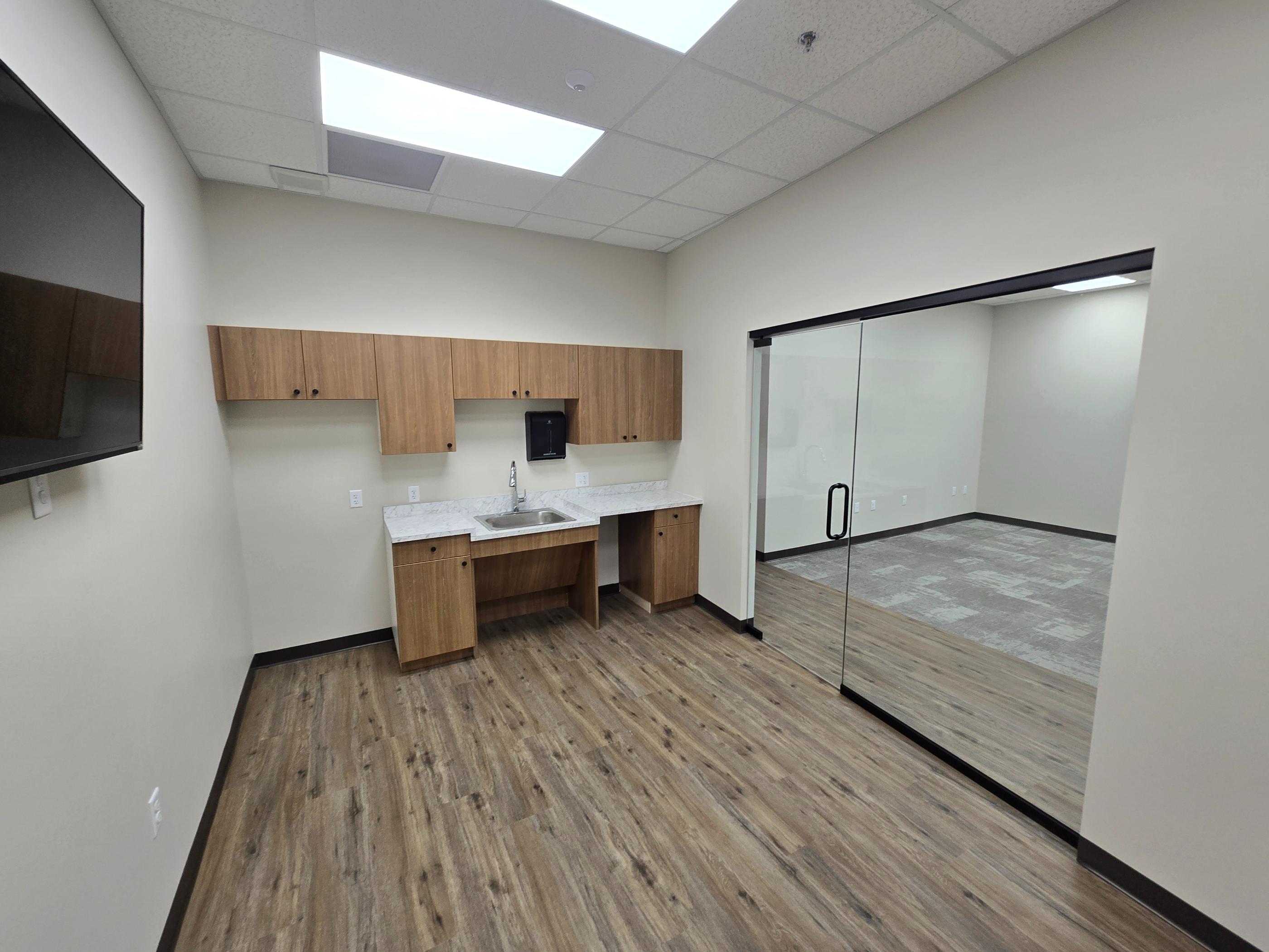 Small office kitchenette with glass-walled conference room