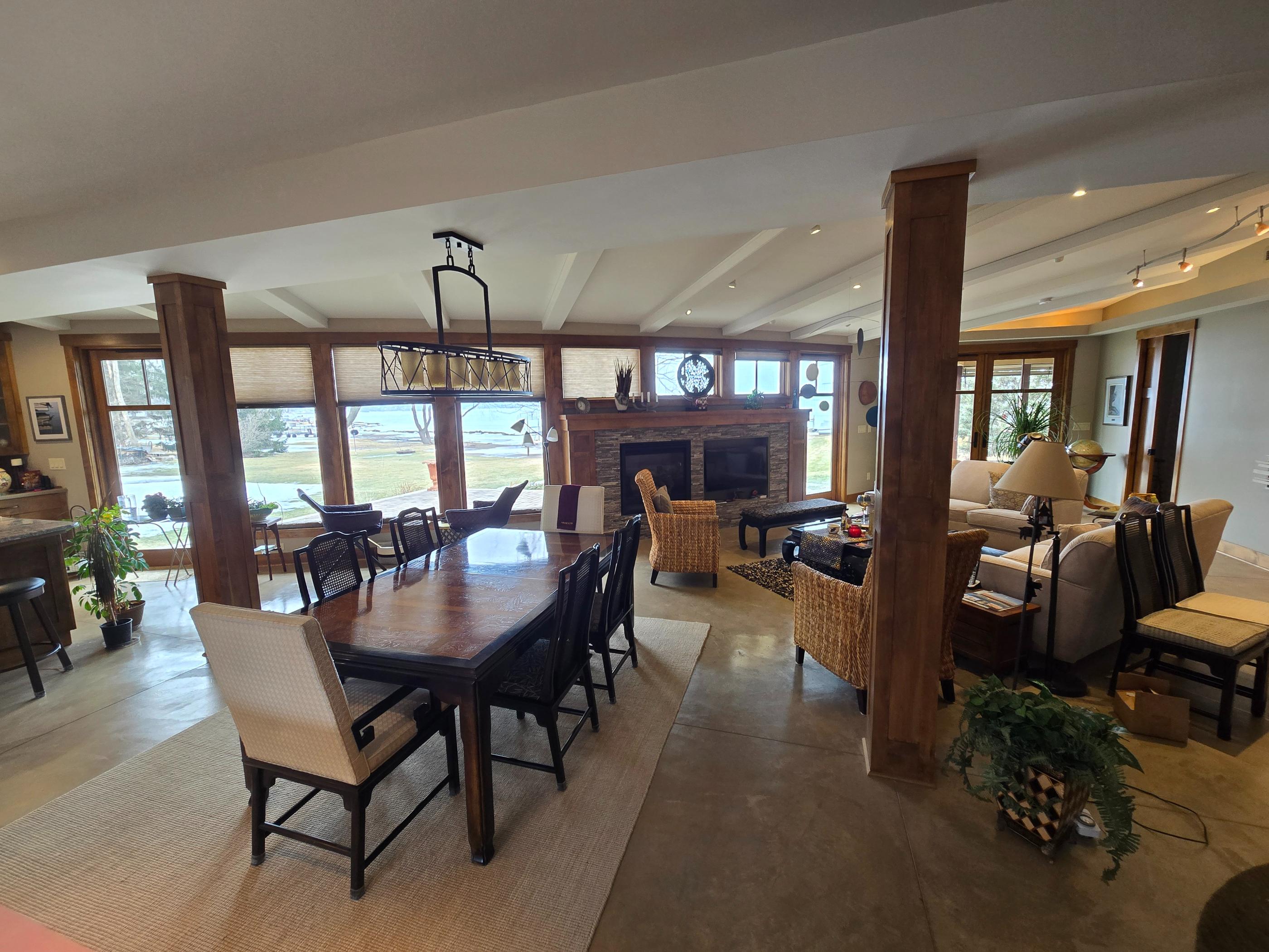 Open living-dining room with fireplace and water view
