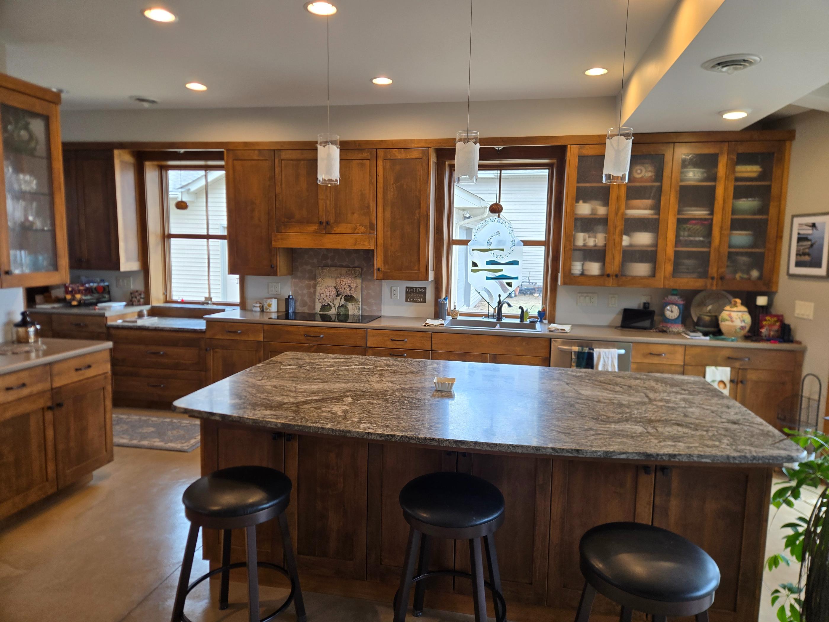 Kitchen with granite island, wood cabinets, stools
