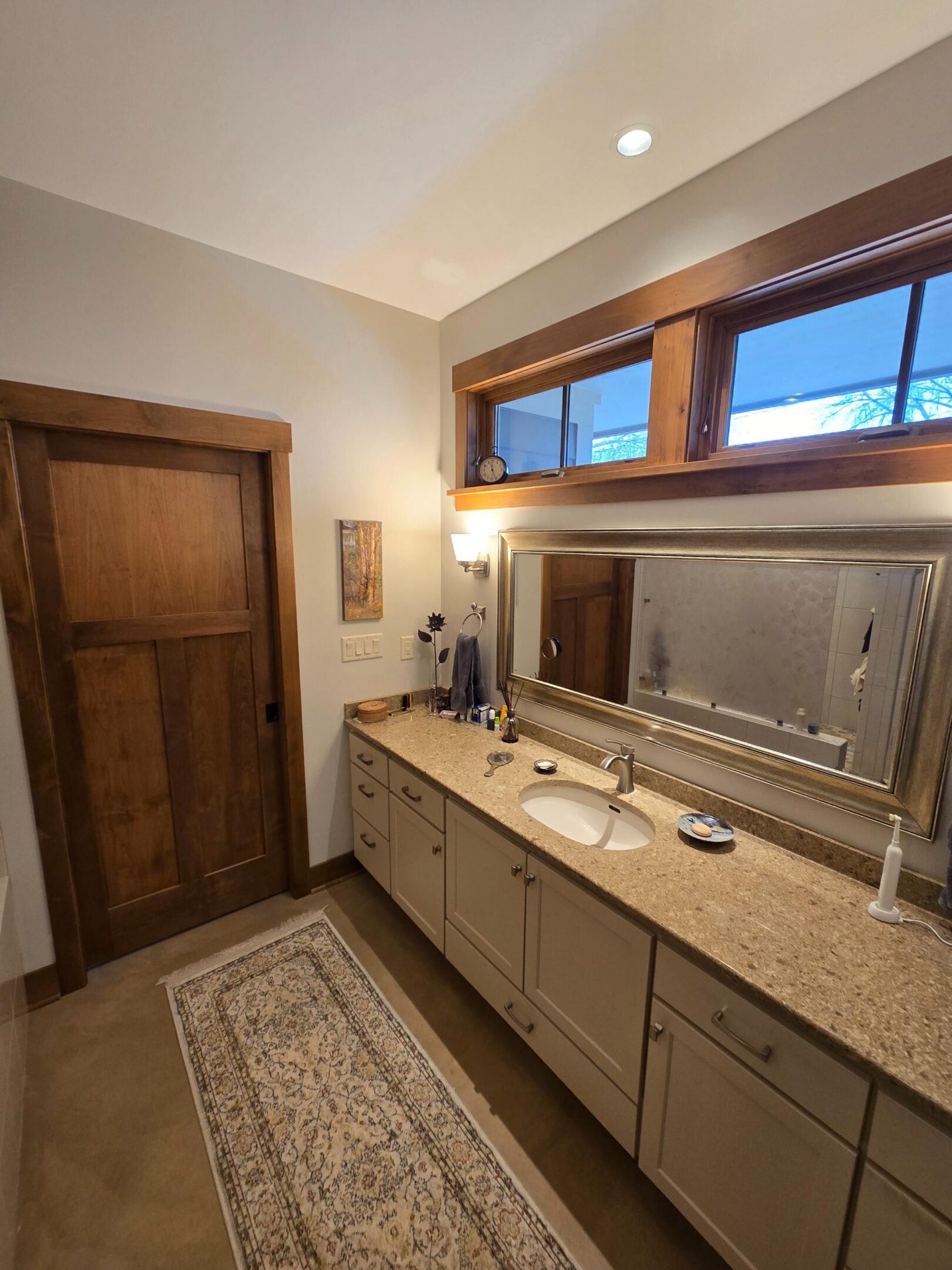 Bathroom vanity with sink, mirror, and rug