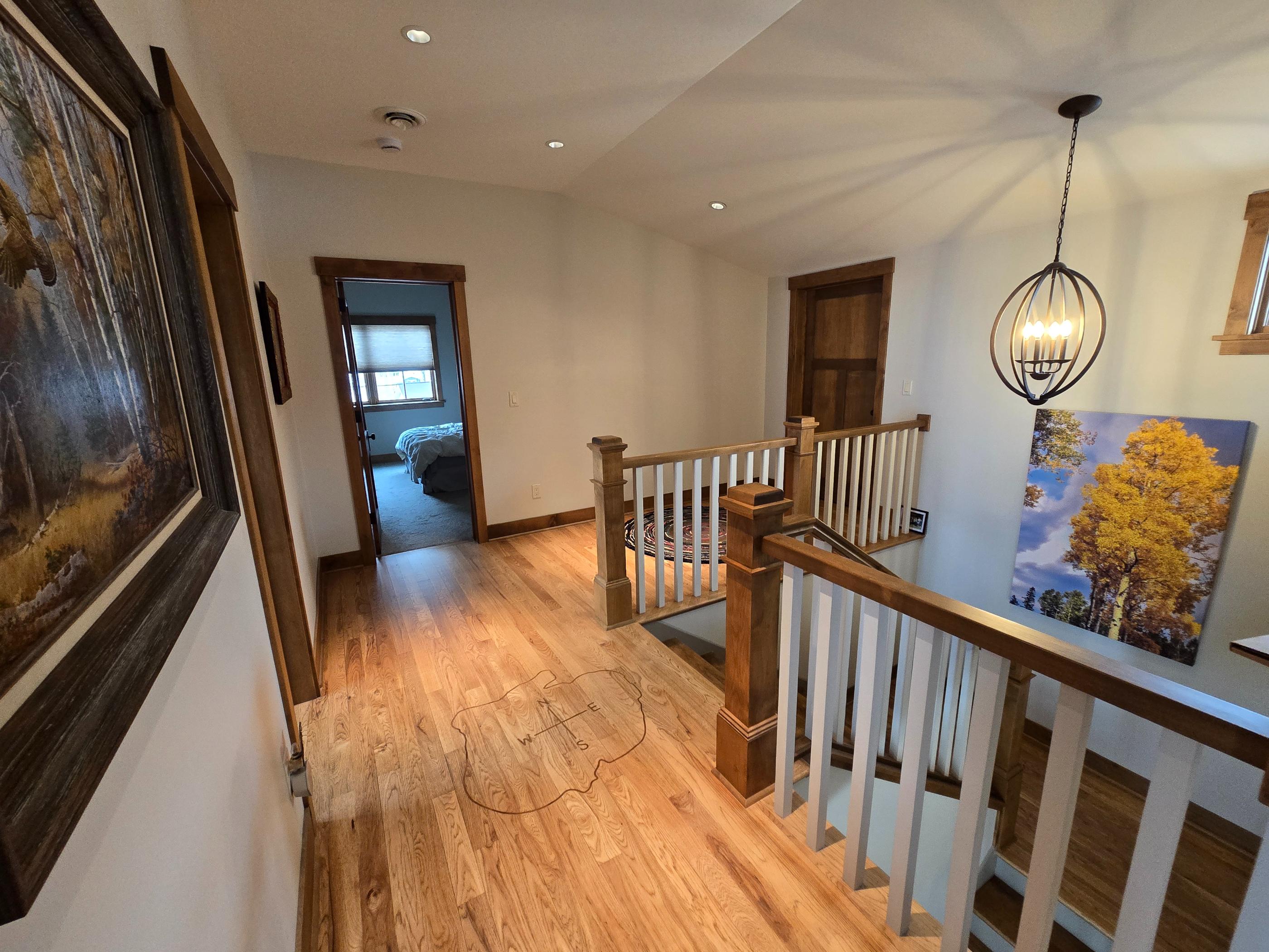Upper hallway with wooden railing and artwork