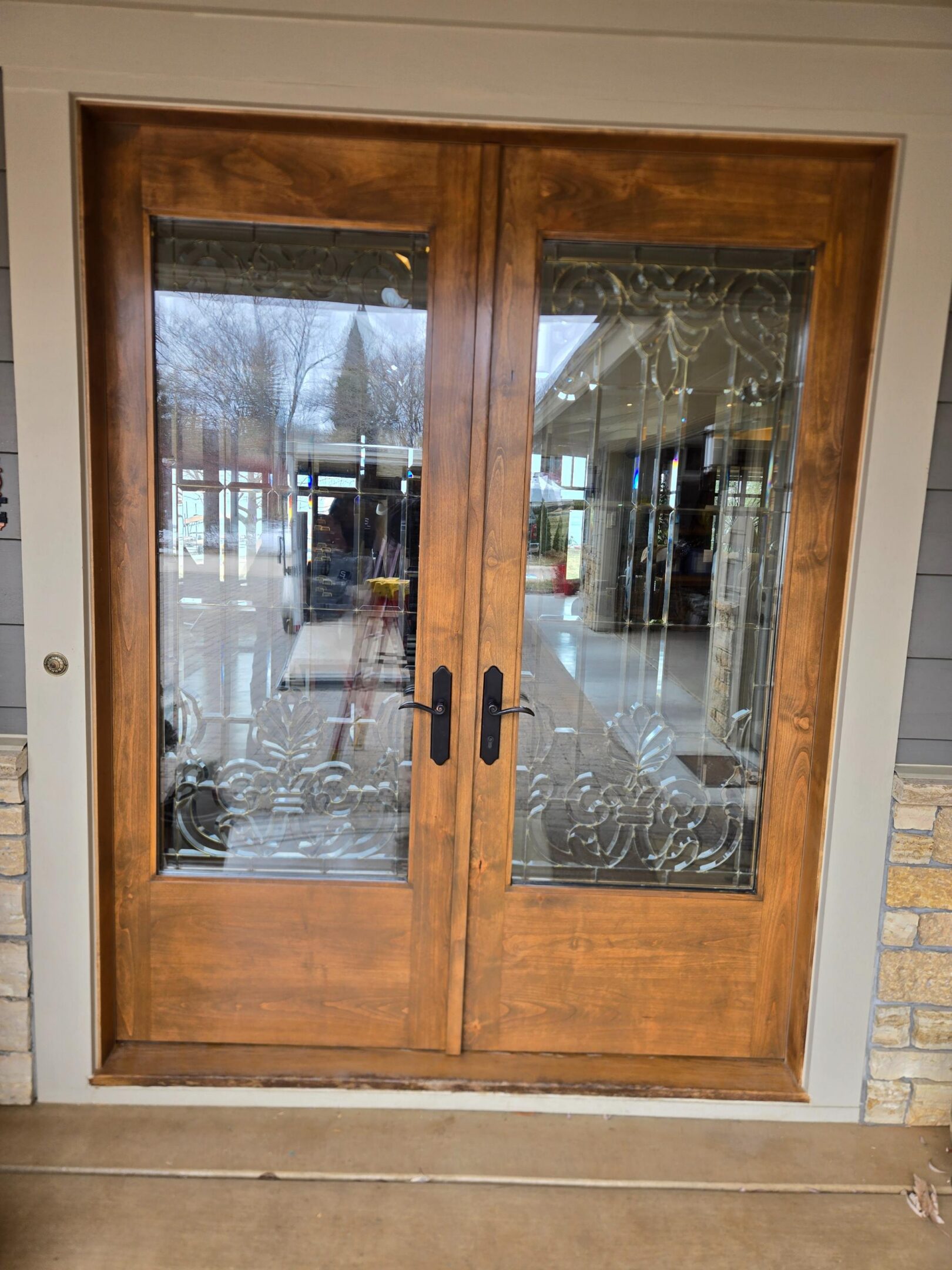 Wooden double doors with decorative glass panels