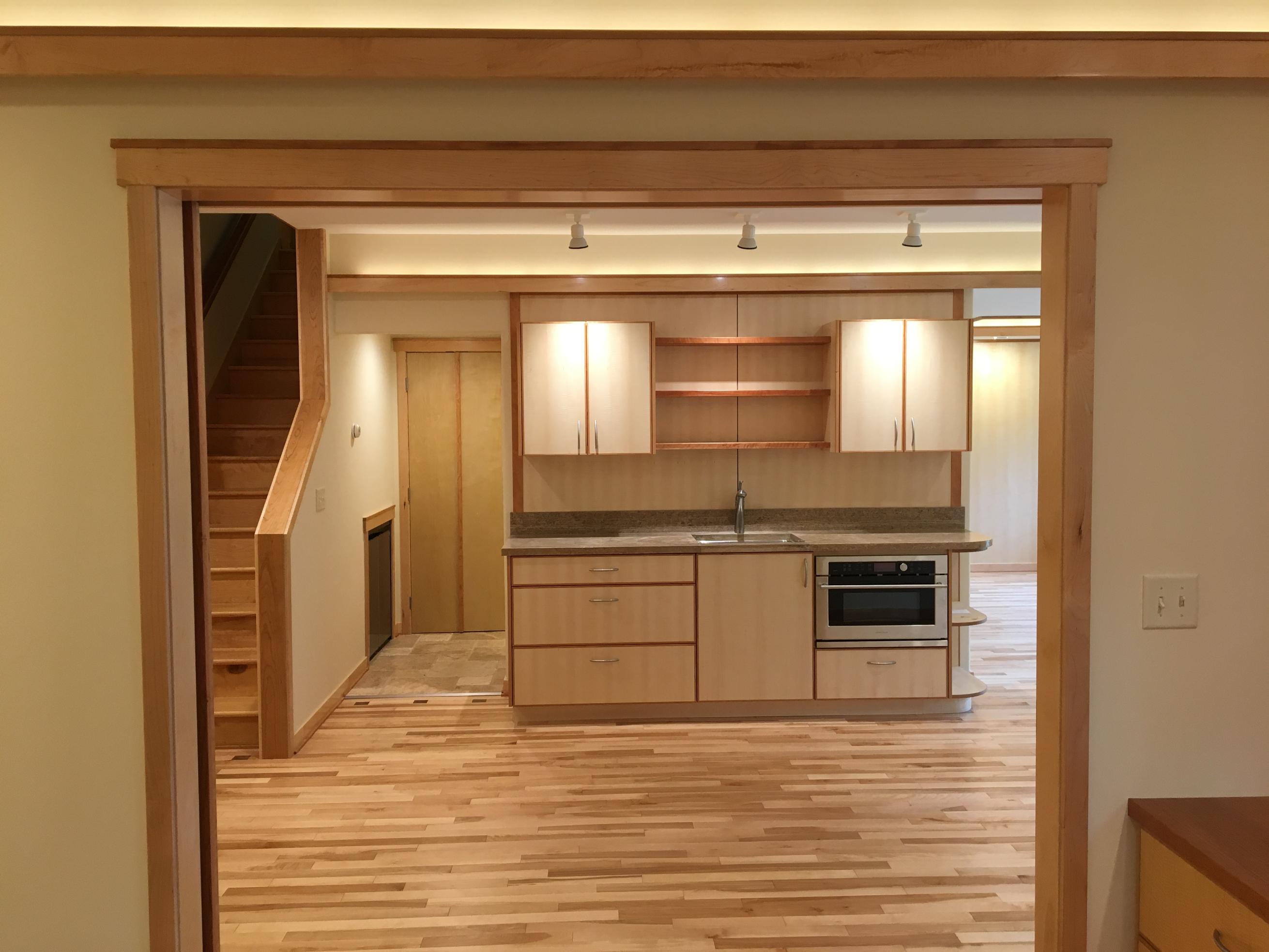 Open-plan light wood kitchen with hardwood floors