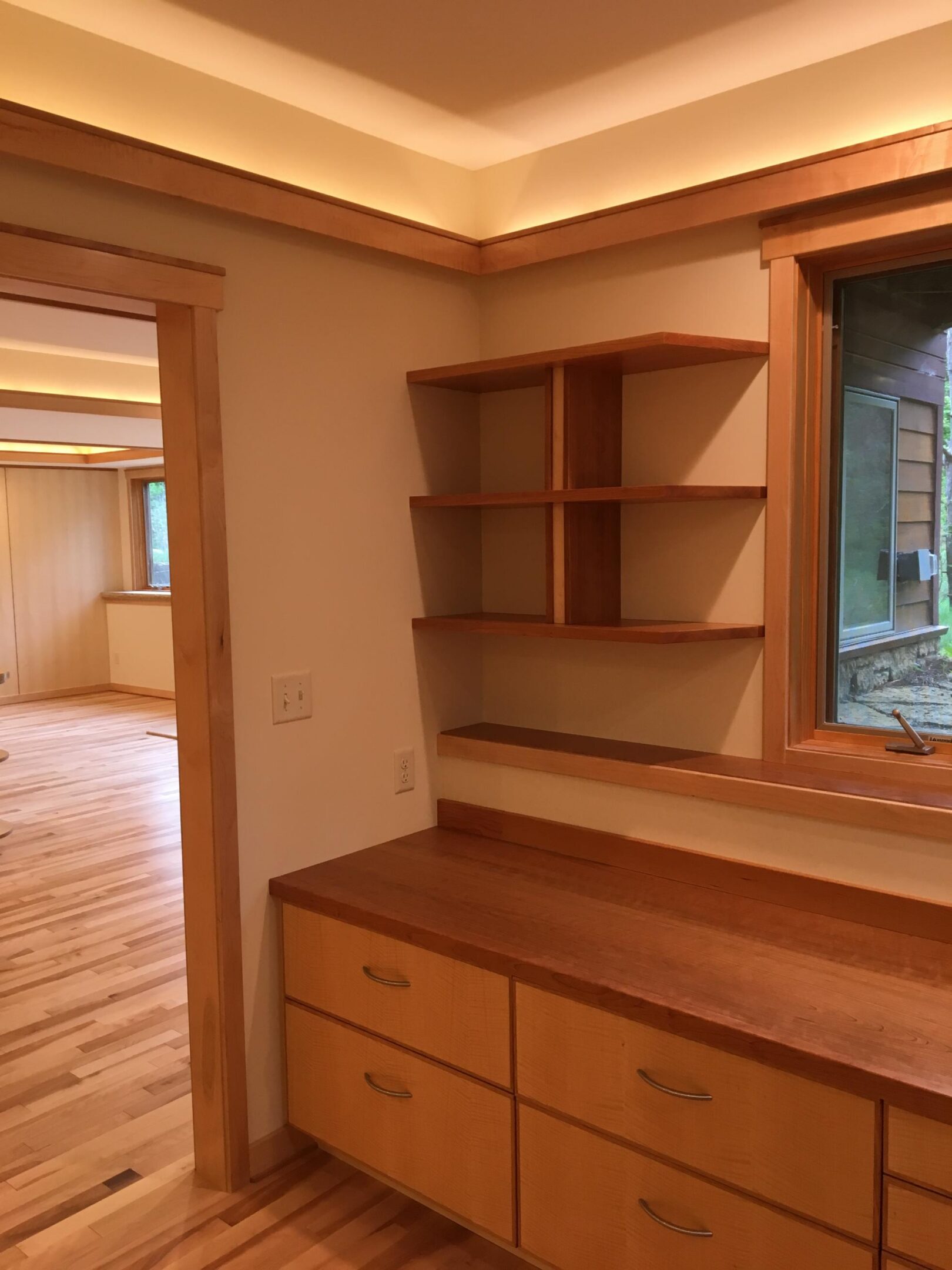 Built-in wooden desk and shelving by window