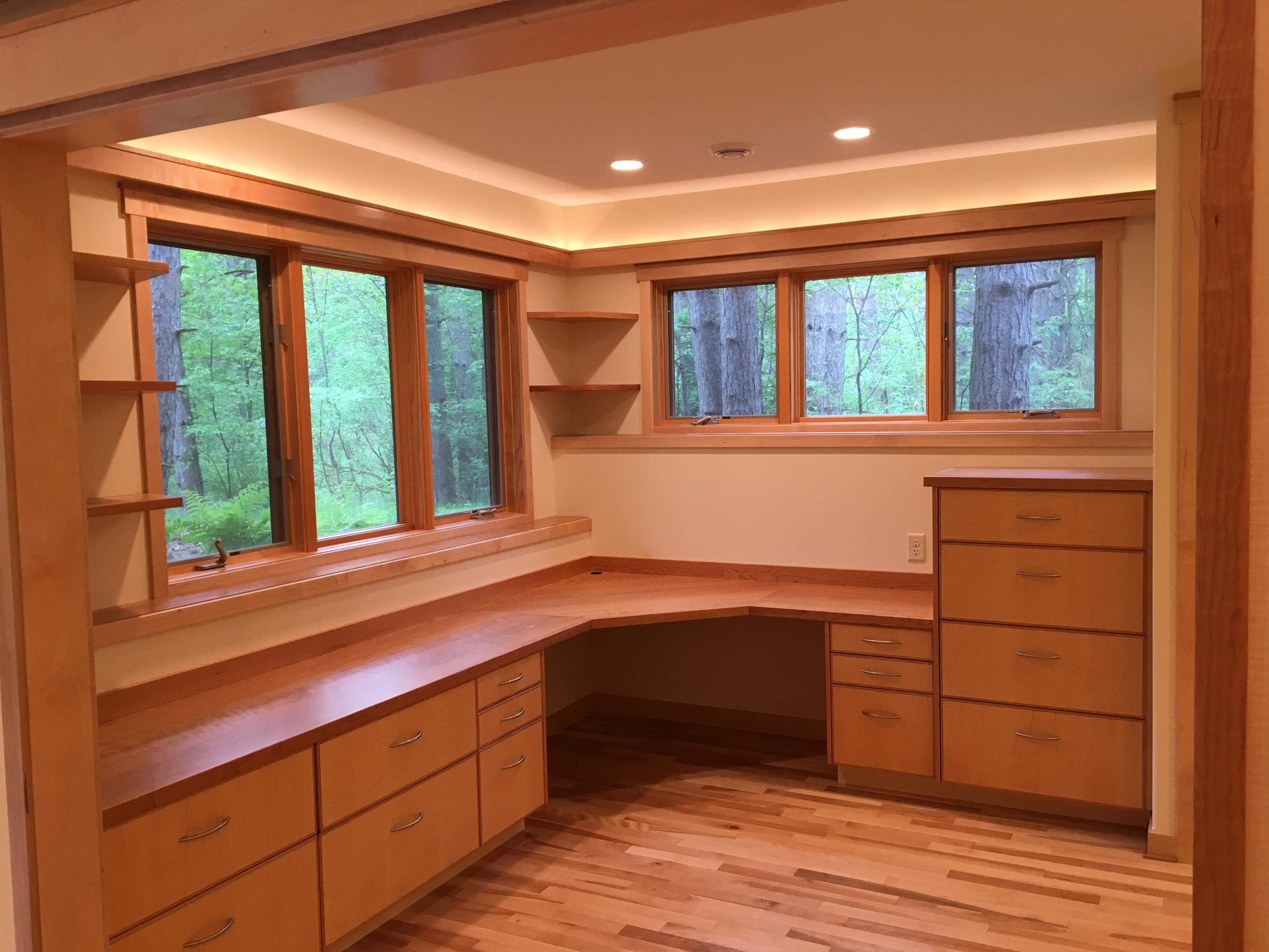 Built-in wooden corner desk with forest view