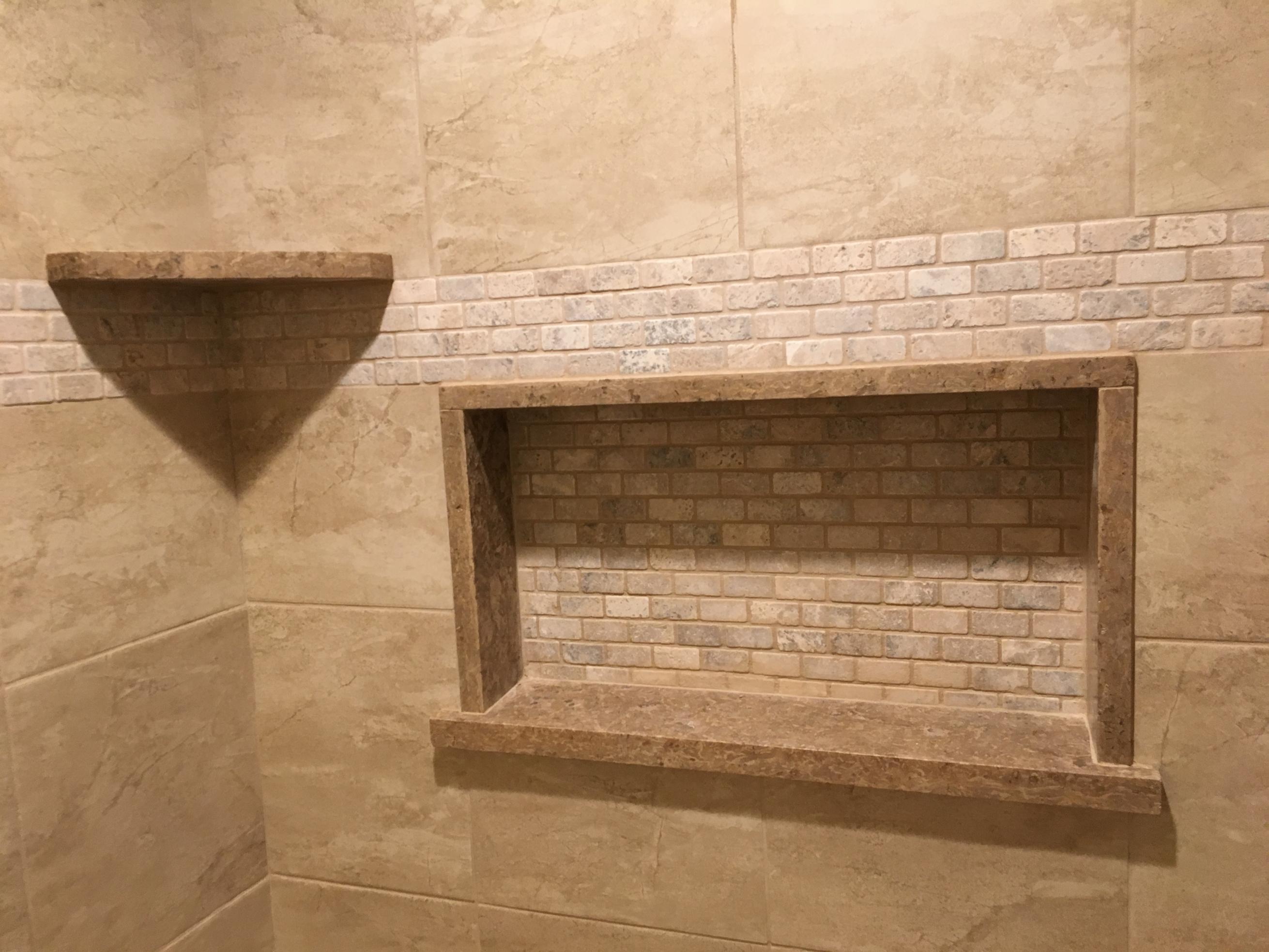 Beige tiled shower wall with recessed niche