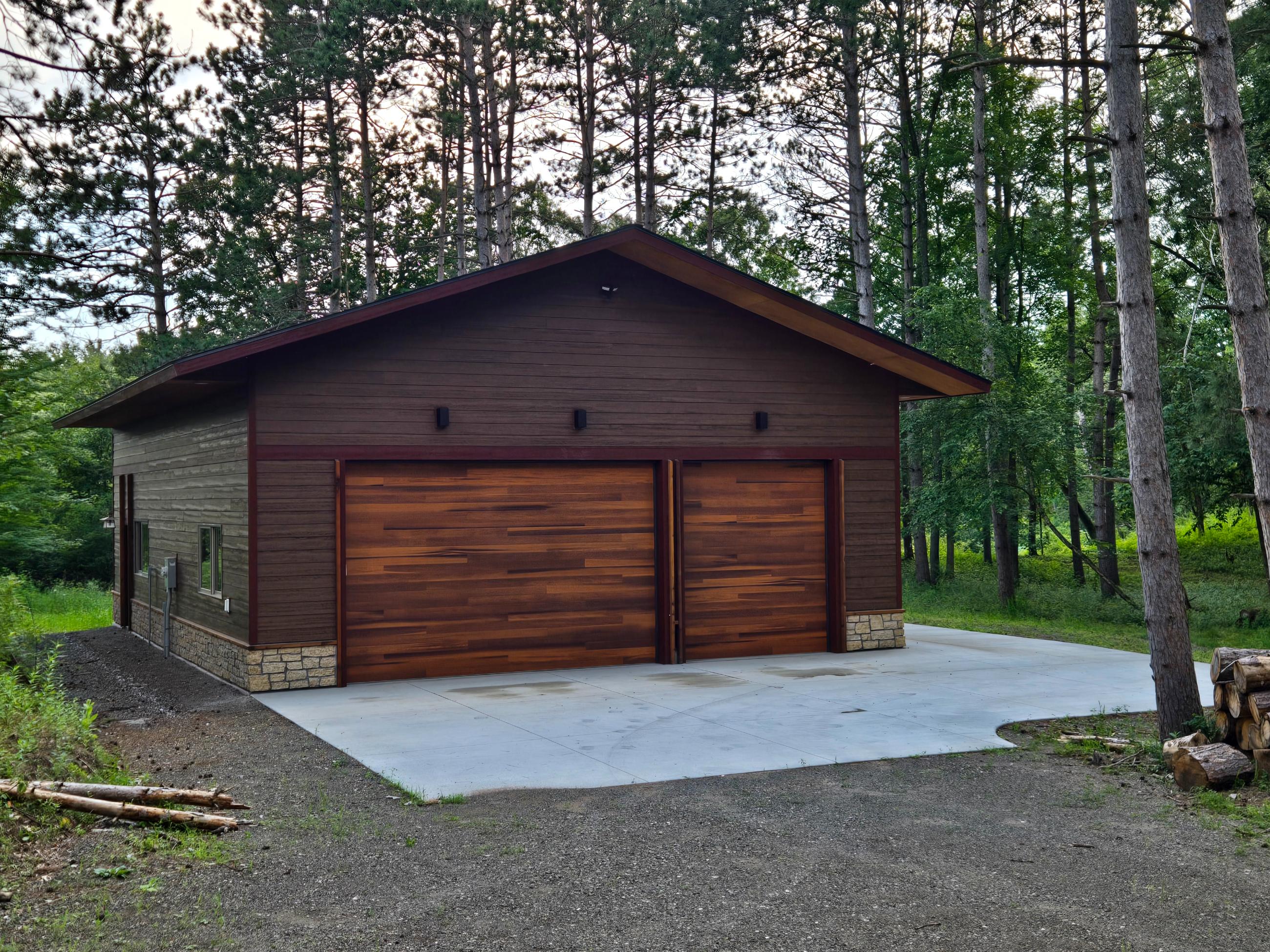 Detached wooden two-car garage among pine trees