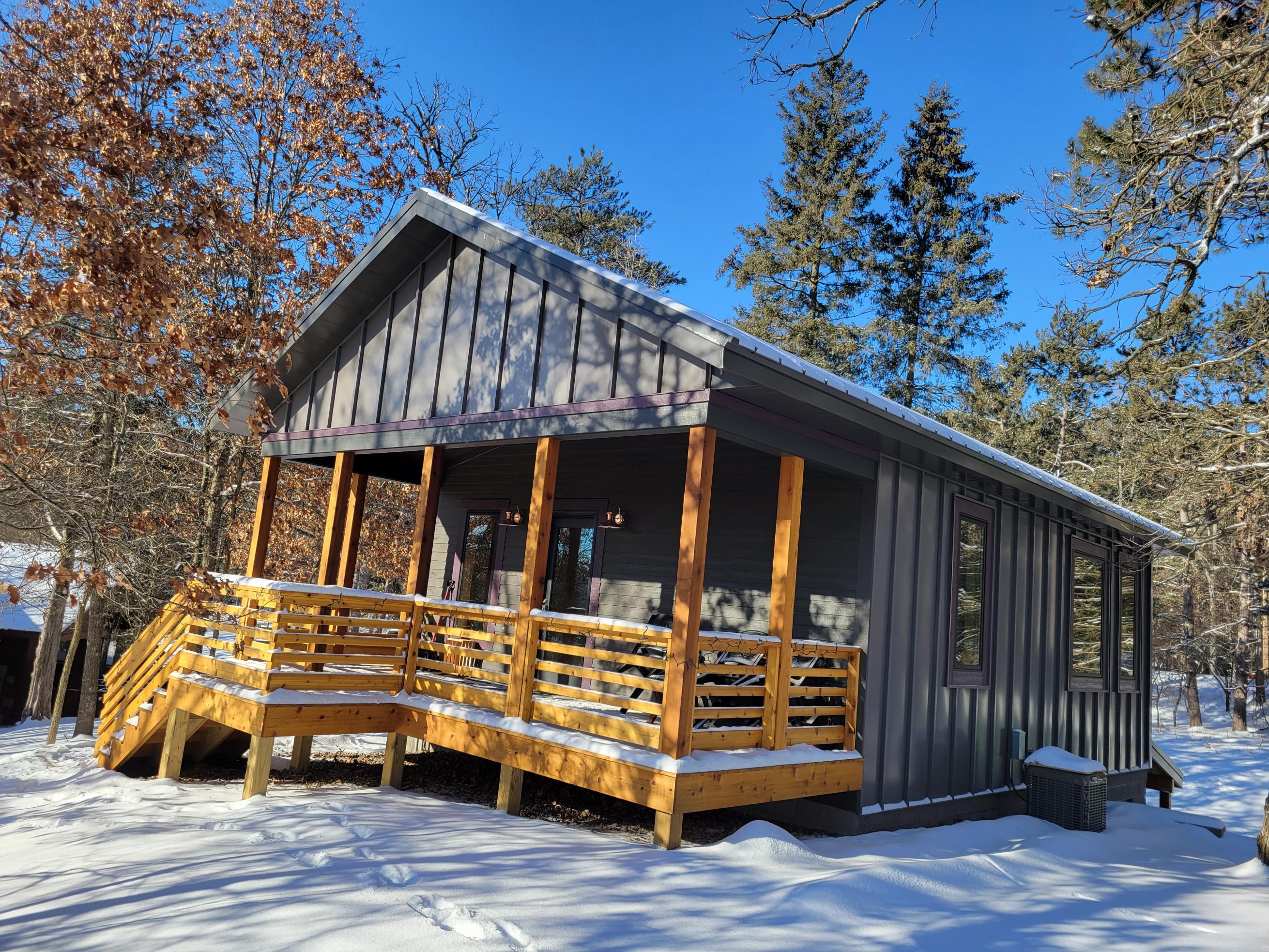 Cozy cabin with snowy porch in forest