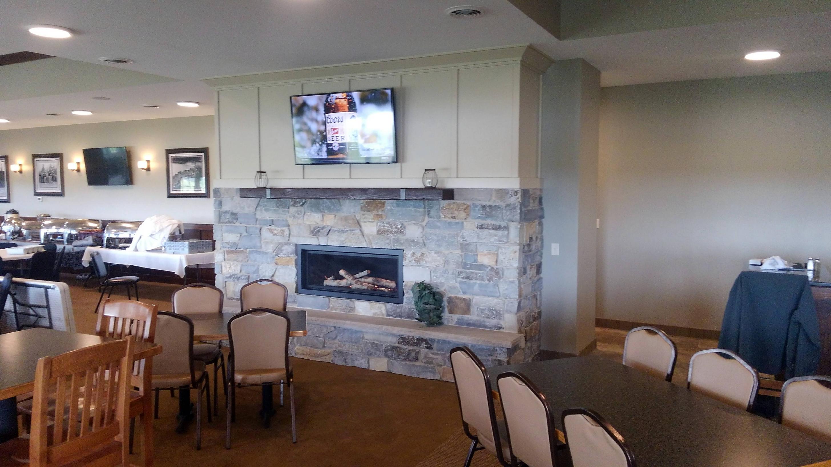Dining lounge with stone fireplace and TV