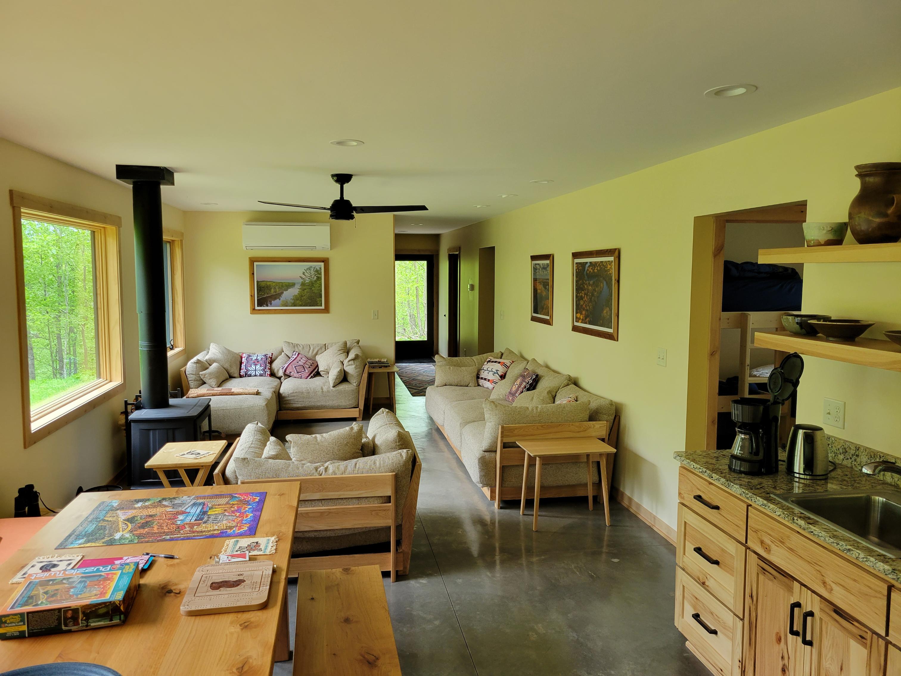 Open-plan living room with sofas and wood stove