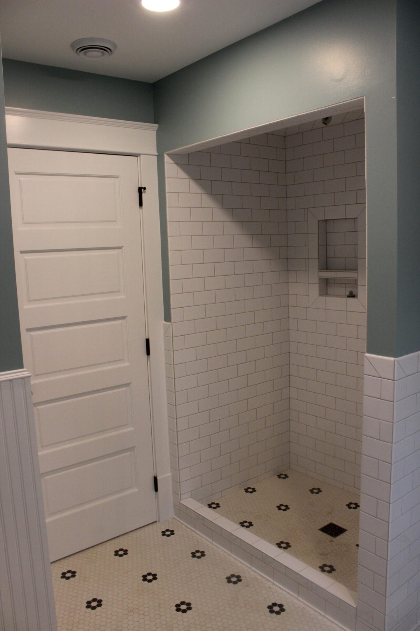 White subway-tiled walk-in shower and door