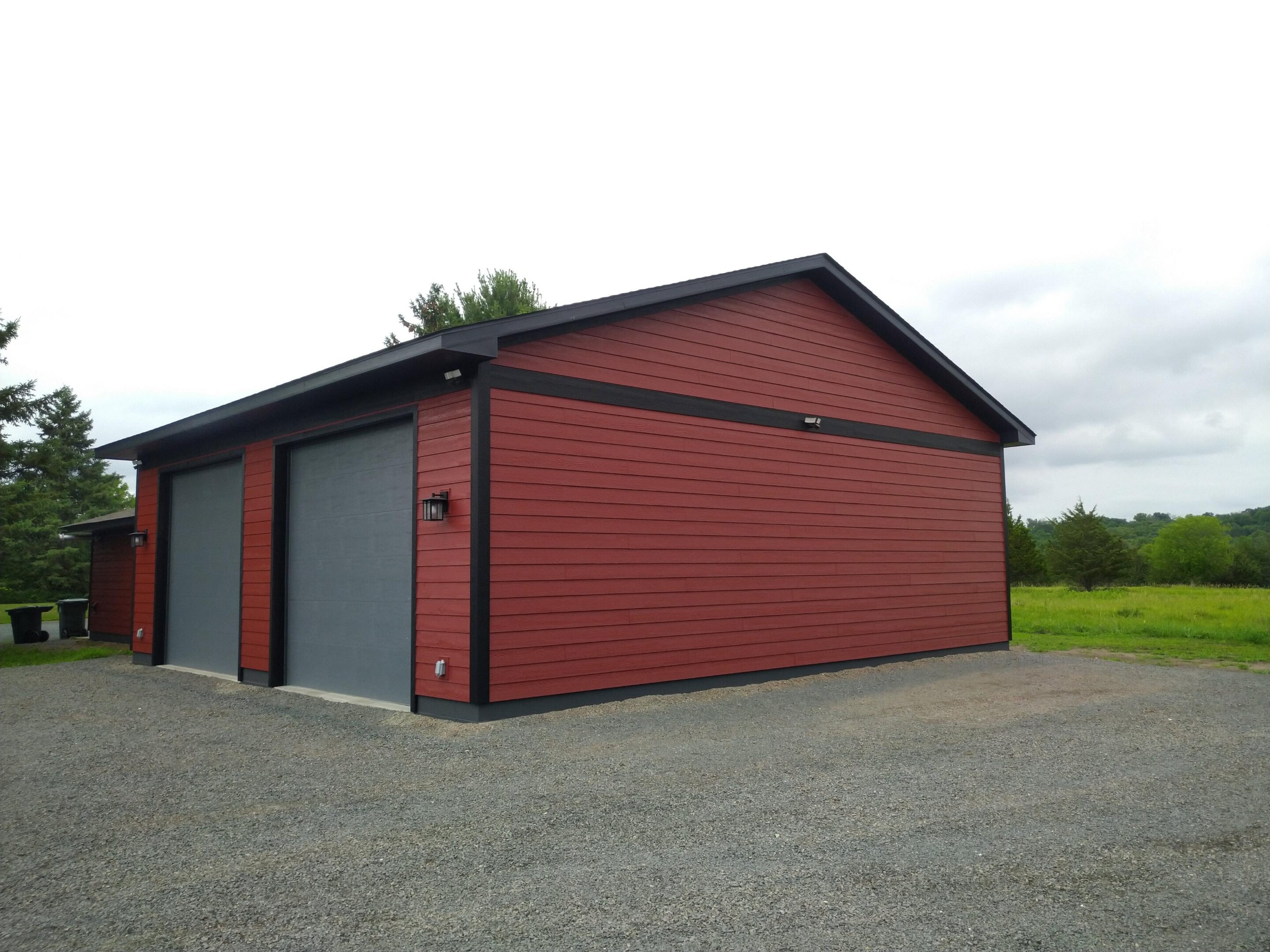 Red detached garage with two gray doors