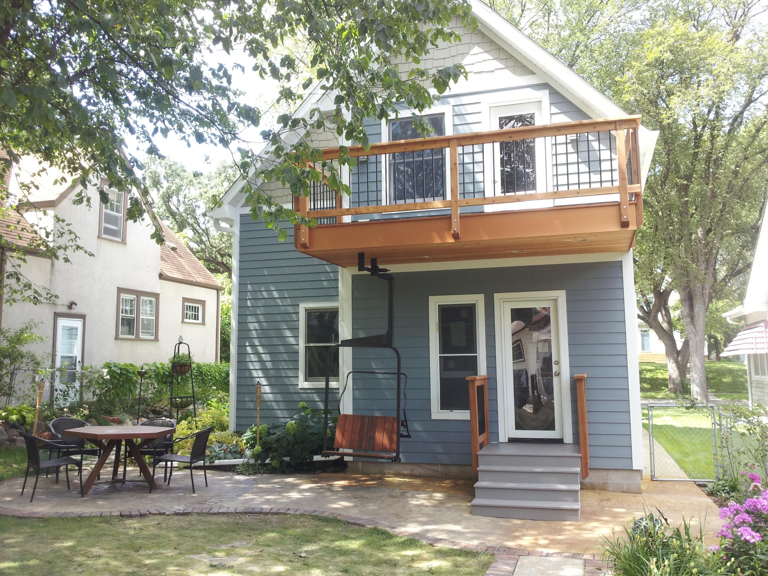 Blue two-story house with balcony and patio